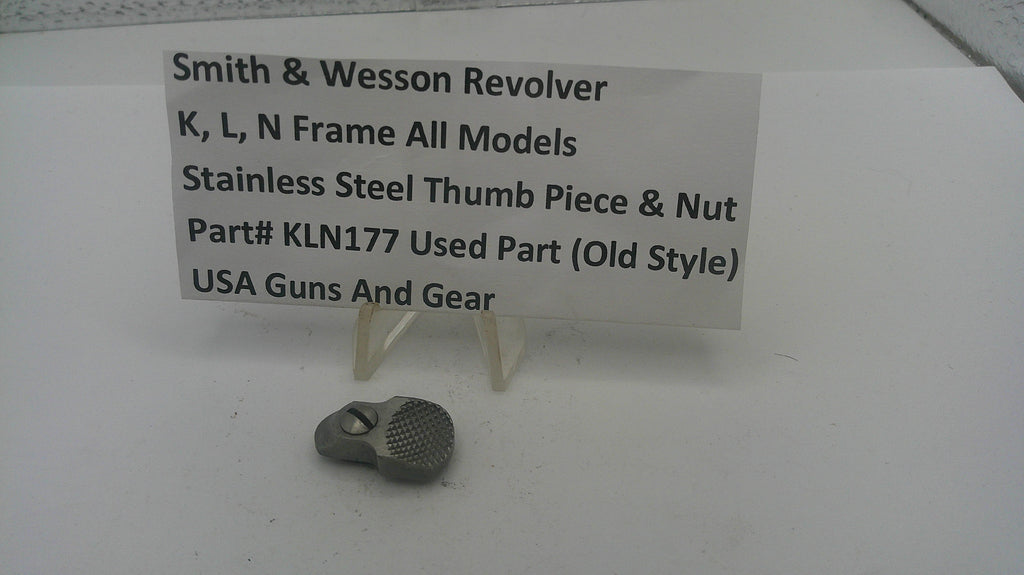 Smith & Wesson revolver thumb piece and nut with a label on a white background