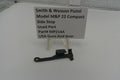 Smith & Wesson pistol part on a white surface with a label