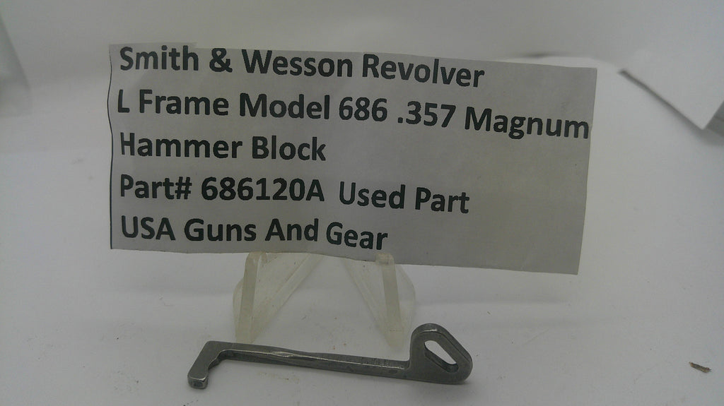 A metal hammer block part for a Smith & Wesson revolver, displayed on a small clear stand with a paper label showing part details and the brand USA Guns And Gear.