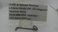 A metal hammer block part for a Smith & Wesson revolver, displayed on a small clear stand with a paper label showing part details and the brand USA Guns And Gear.