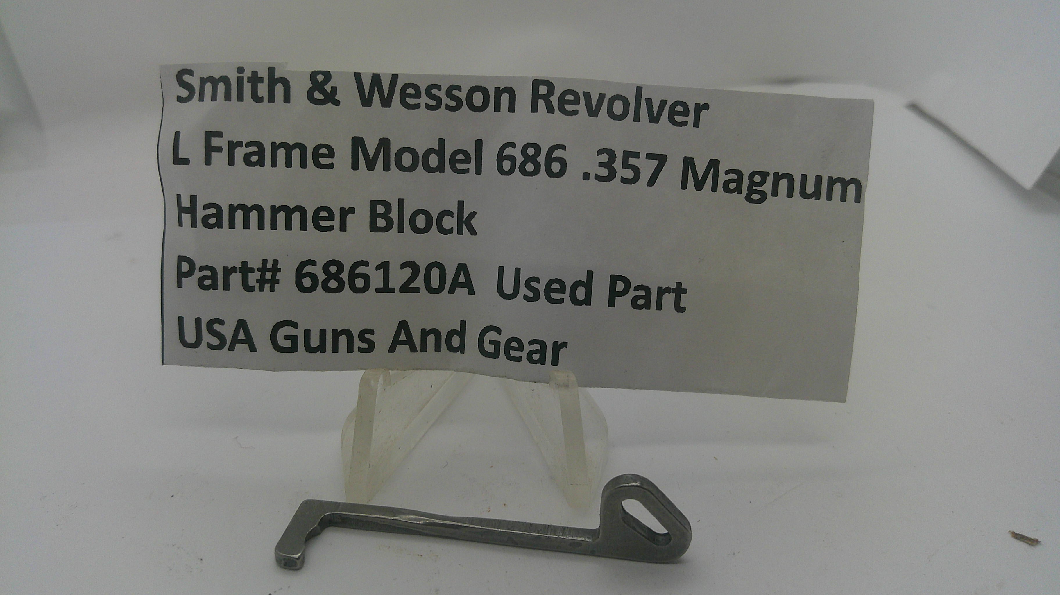 A metal hammer block part for a Smith & Wesson revolver, displayed on a small clear stand with a paper label showing part details and the brand USA Guns And Gear.