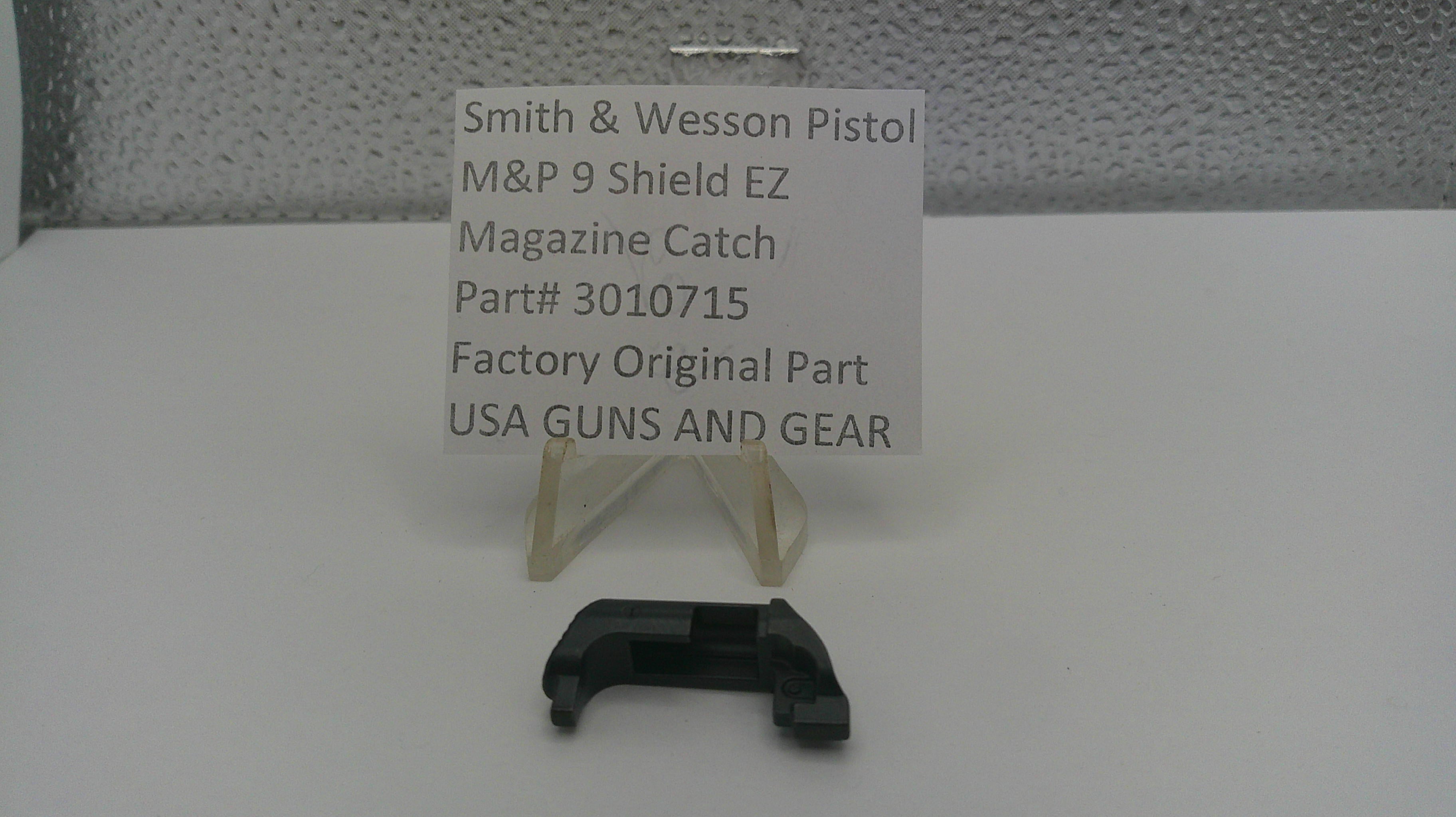 Smith & Wesson pistol magazine catch with a label on a white surface