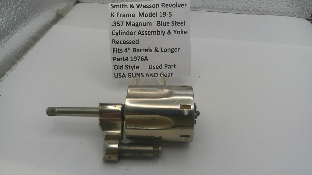 Smith & Wesson revolver cylinder assembly on a white surface with a label.