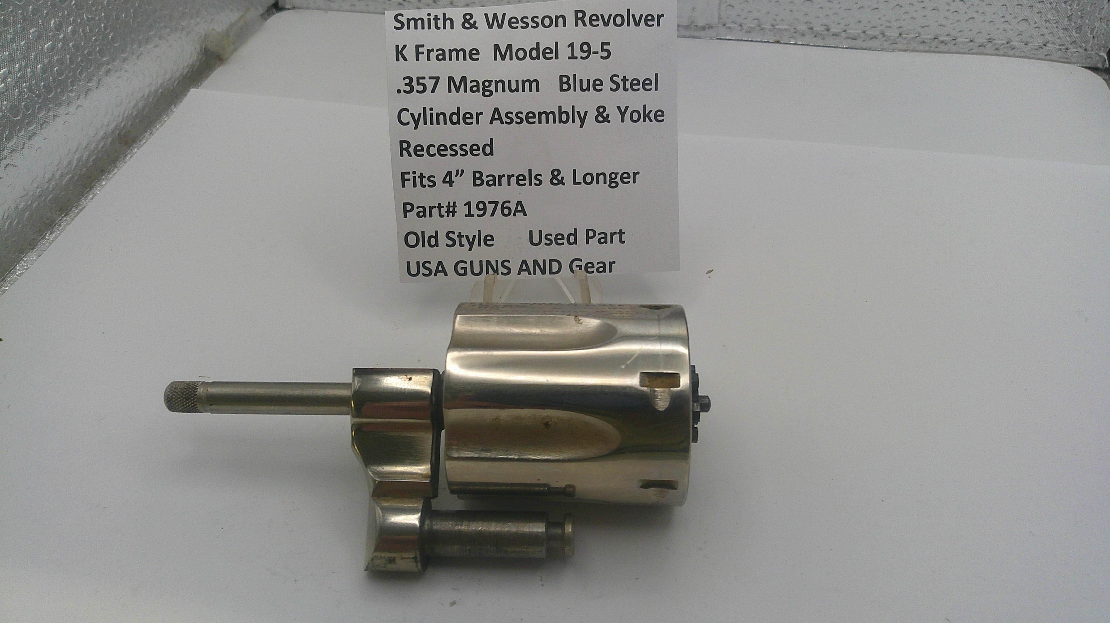 Smith & Wesson revolver cylinder assembly on a white surface with a label.