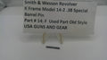 A small dark metal barrel pin displayed on a white stand in front of a white sign that reads 'Smith & Wesson Revolver K Frame Model 14-2 .38 Special Barrel Pin Part # 14-F Used Part Old Style USA GUNS AND GEAR'.