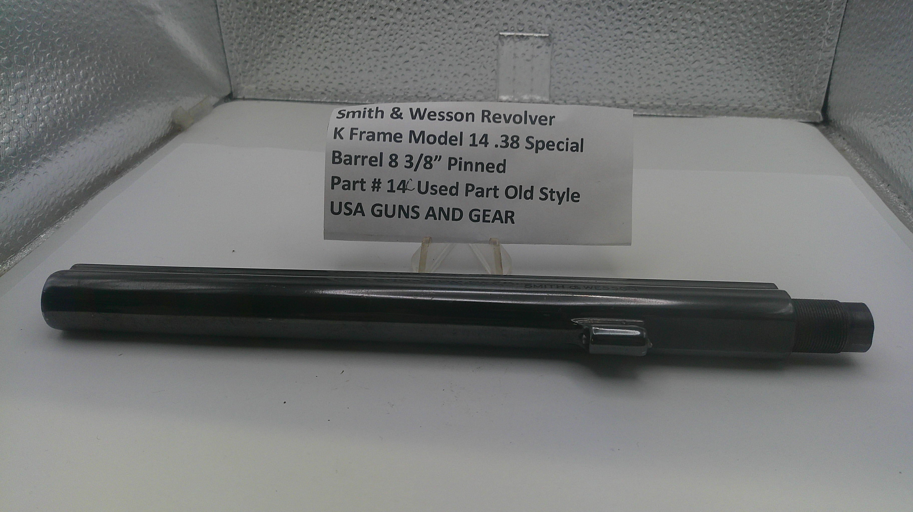 A black metal barrel component for a Smith & Wesson revolver, displayed horizontally in front of a white label card on a light gray textured background.