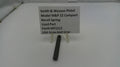 Smith & Wesson pistol recoil spring on a white surface with a label.