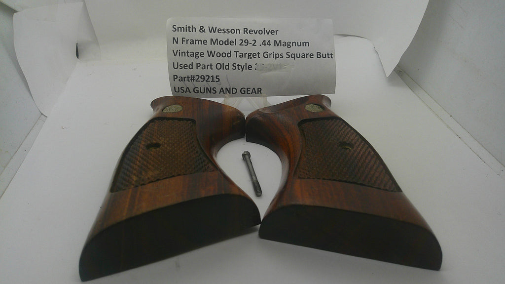 A pair of vintage wood revolver grip butts for a Smith & Wesson Model 29-2 .44 Magnum, shown inside their original white box with an inventory label card and a small metal screw.
