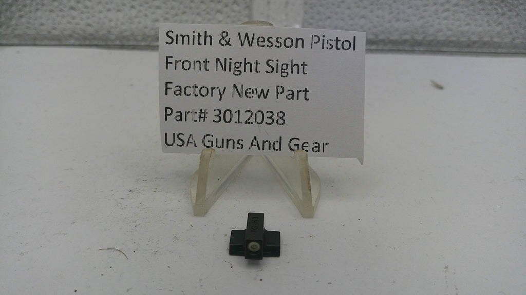 Smith & Wesson pistol front night sight on a white surface with a label.