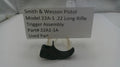 Smith & Wesson pistol trigger assembly on a stand with a label