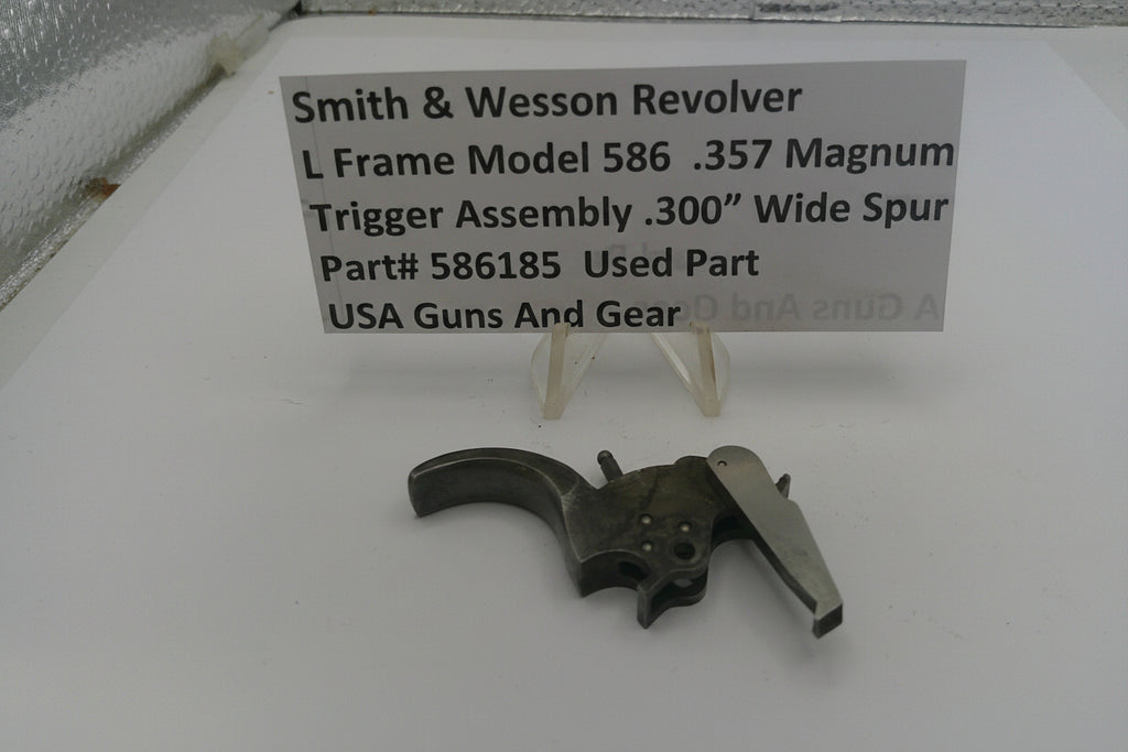 Smith & Wesson revolver trigger assembly on a white surface with a label.