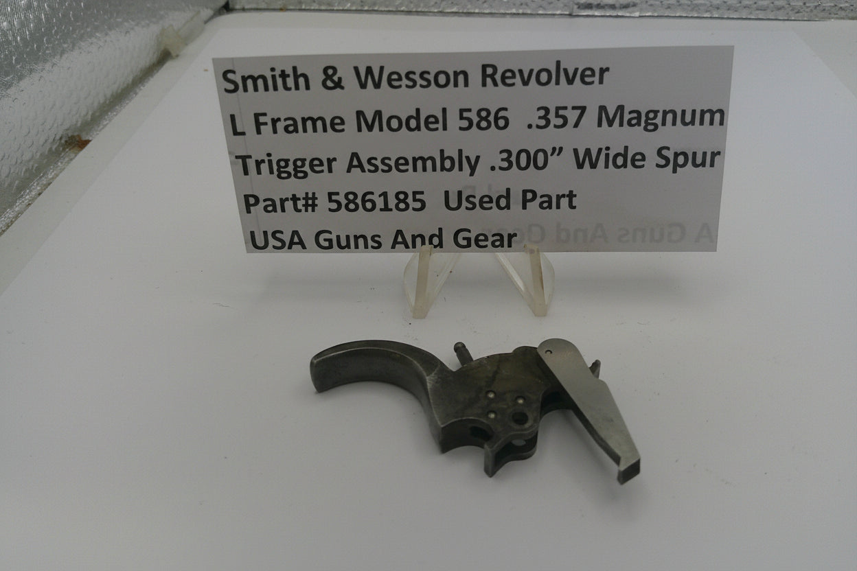 Smith & Wesson revolver trigger assembly on a white surface with a label.