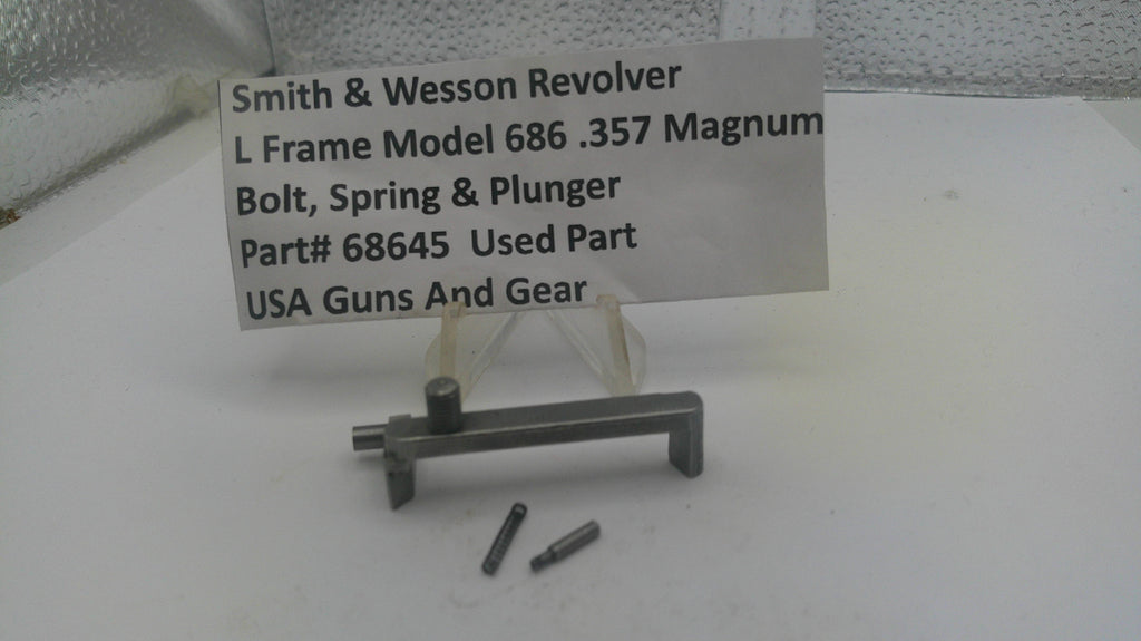 Smith & Wesson revolver parts on a white surface with a label.