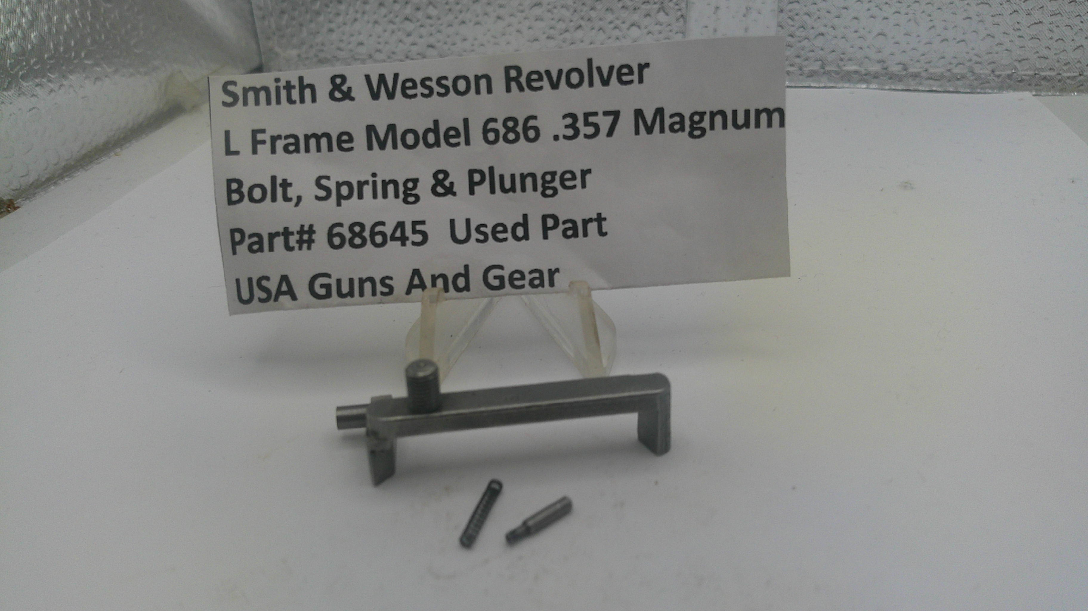 Smith & Wesson revolver parts on a white surface with a label.