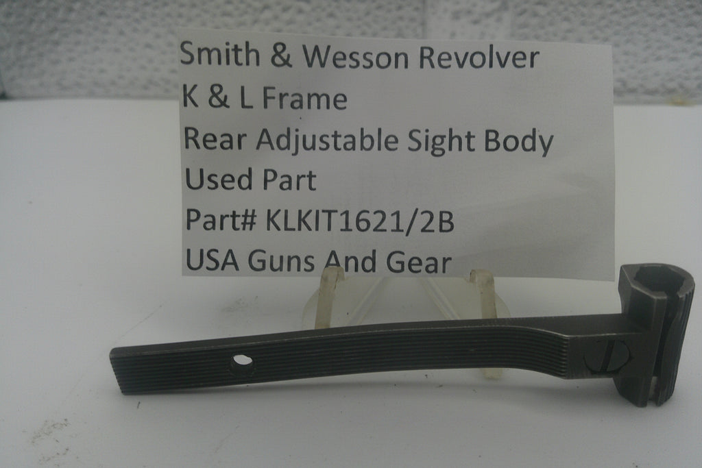 A used black metal sight body part for a Smith & Wesson revolver, displayed on a small stand in front of a white card with product details.