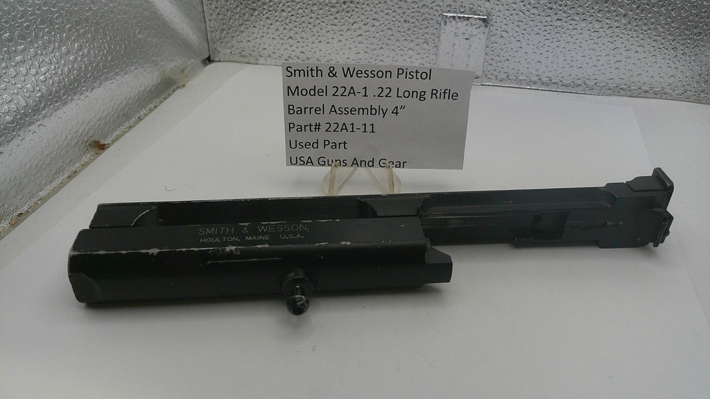 Smith & Wesson pistol barrel assembly on a white surface with a label.