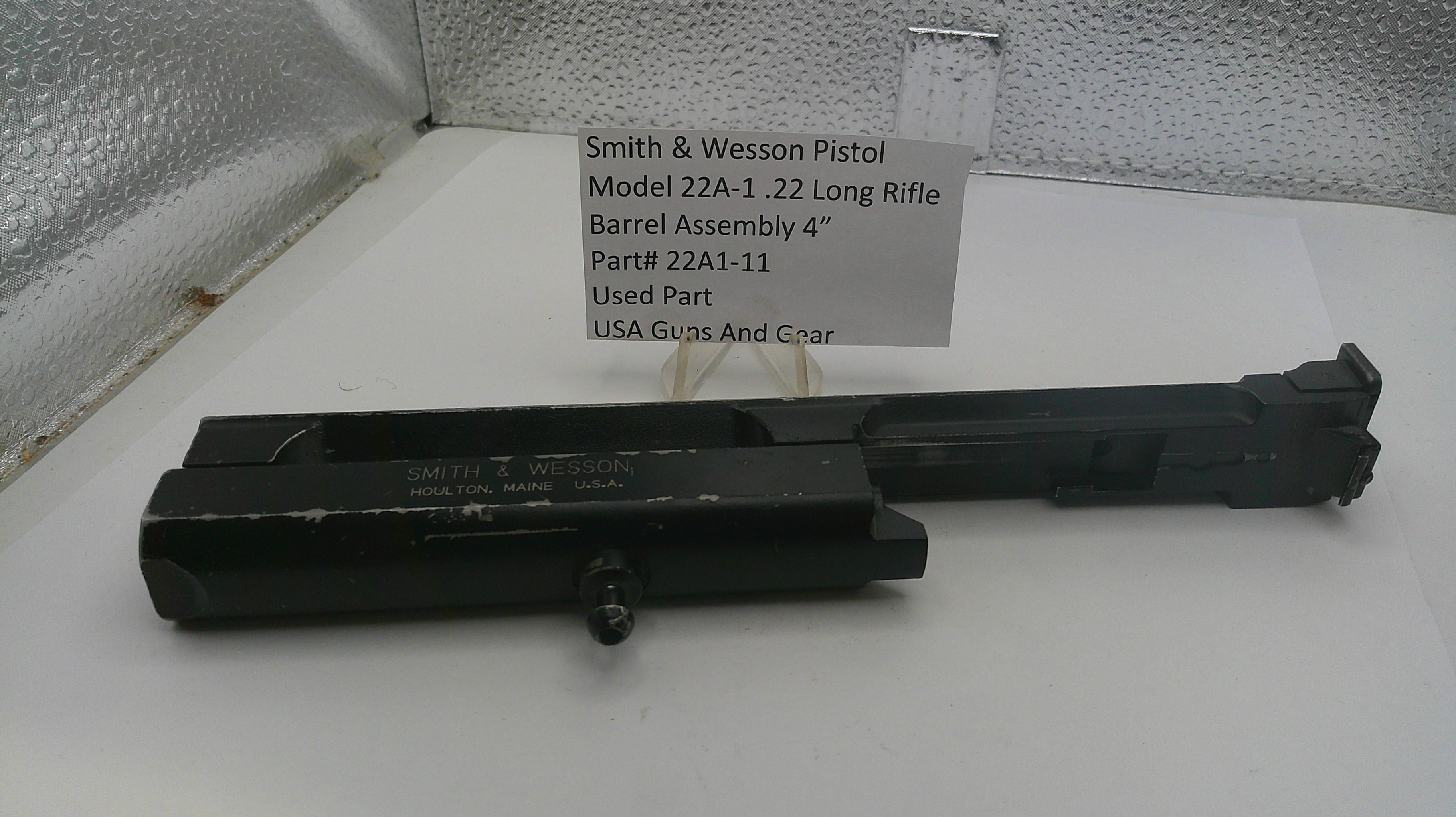 Smith & Wesson pistol barrel assembly on a white surface with a label.