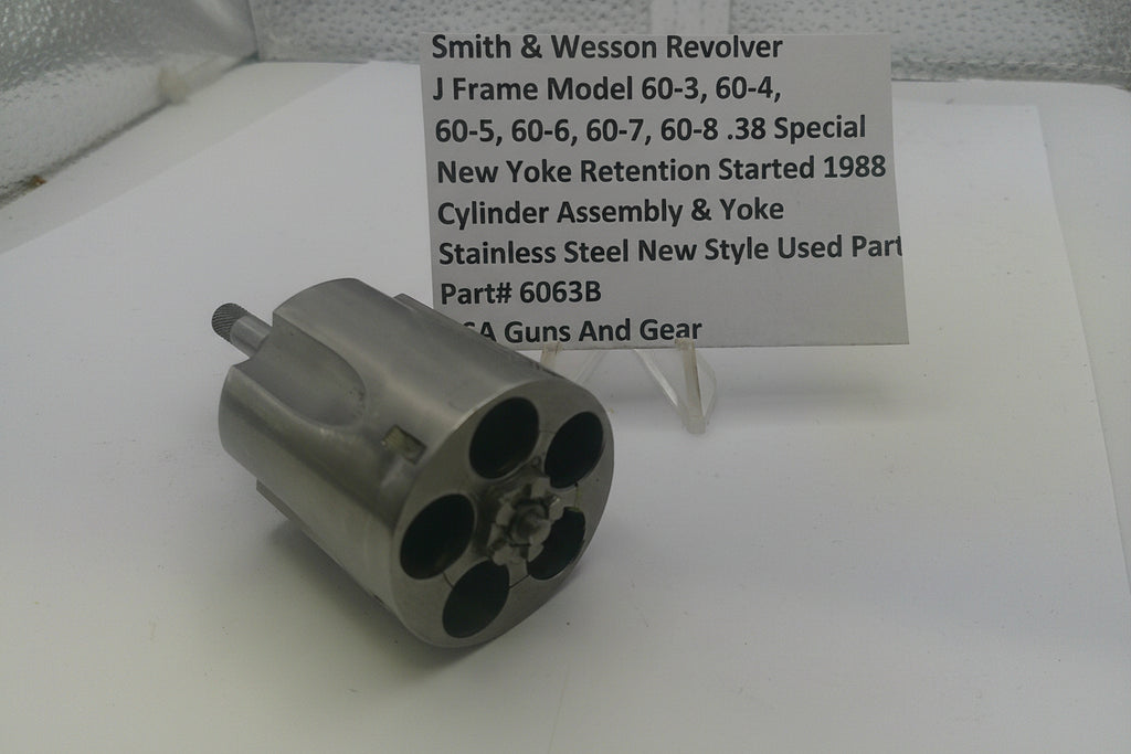 Smith & Wesson revolver cylinder assembly on a white surface with a label.