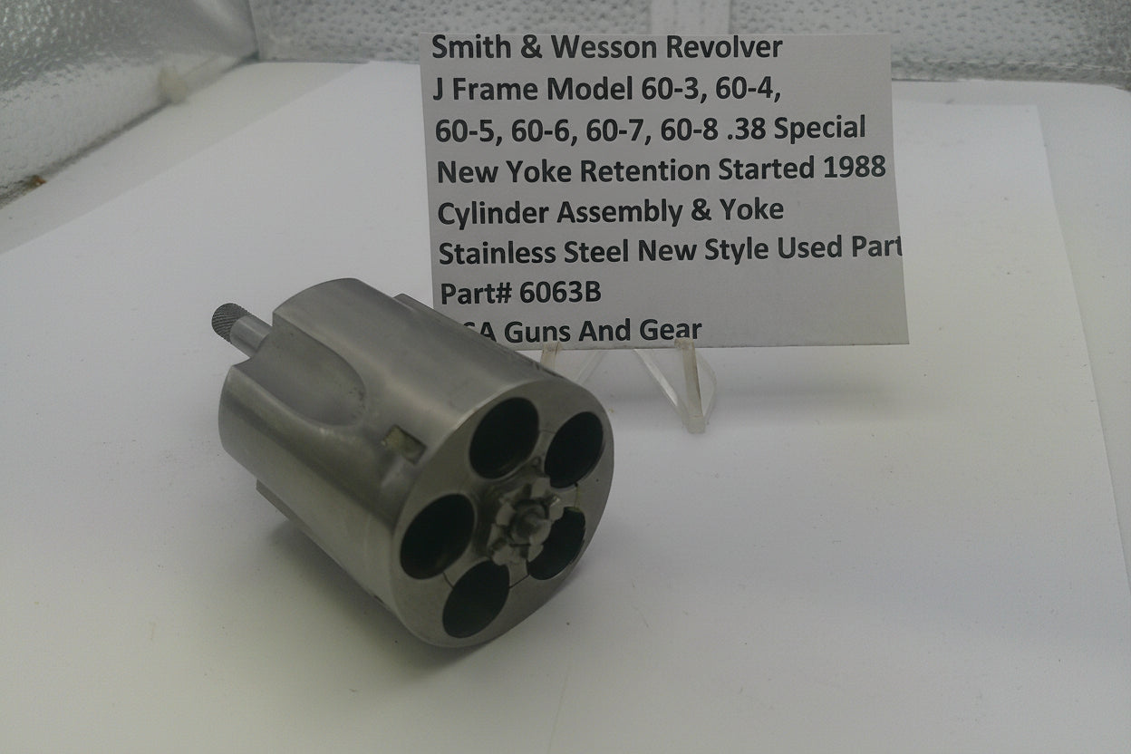 Smith & Wesson revolver cylinder assembly on a white surface with a label.