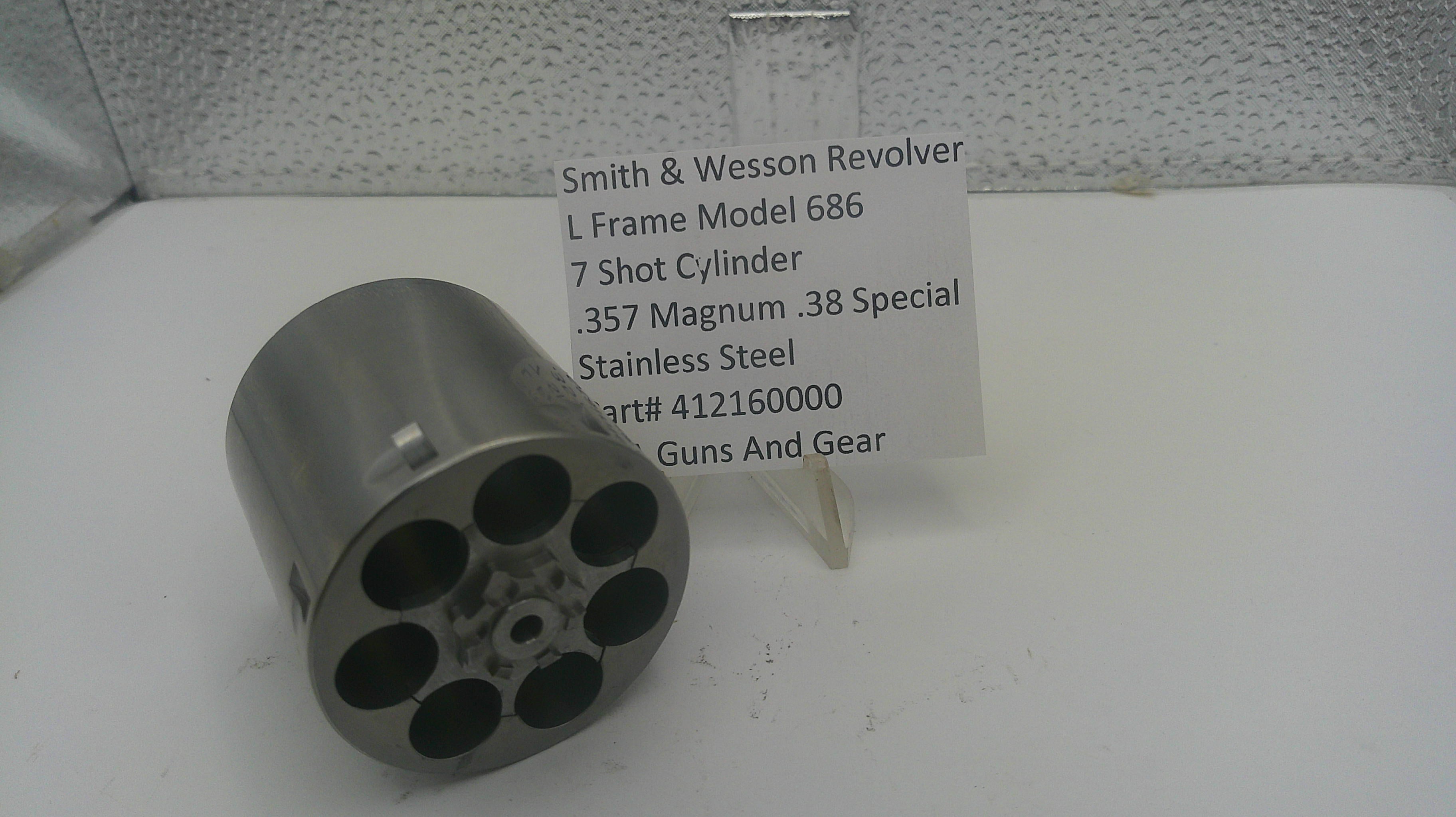 A stainless steel 7-cylinder revolver cylinder holder, shown next to a white label card identifying it as a Smith & Wesson revolver part.