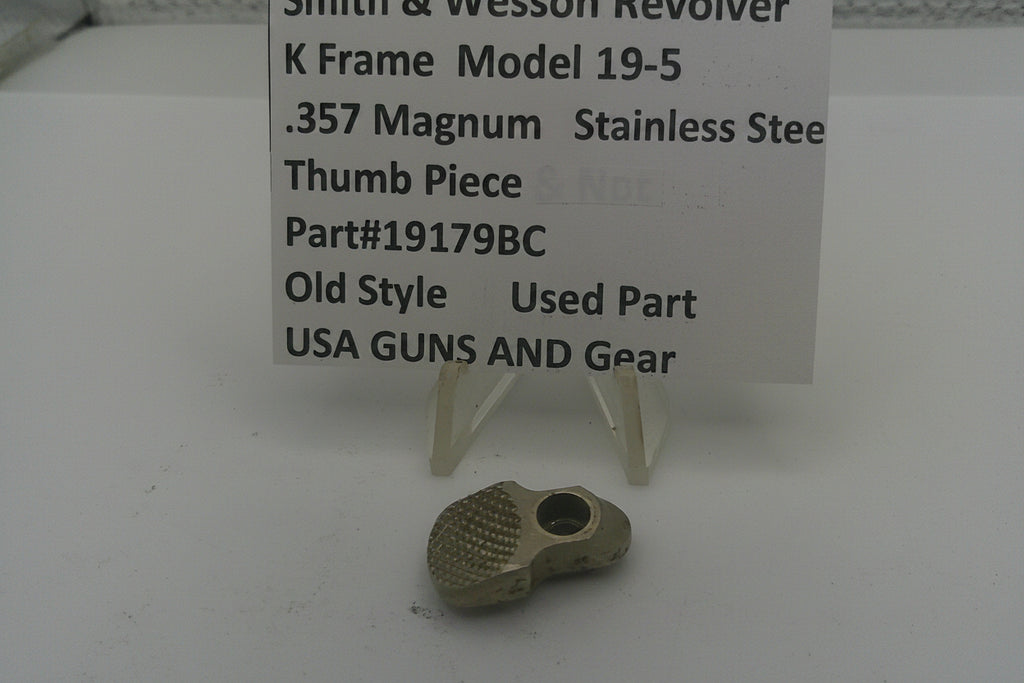 Smith & Wesson revolver thumb piece with descriptive sign on a white background