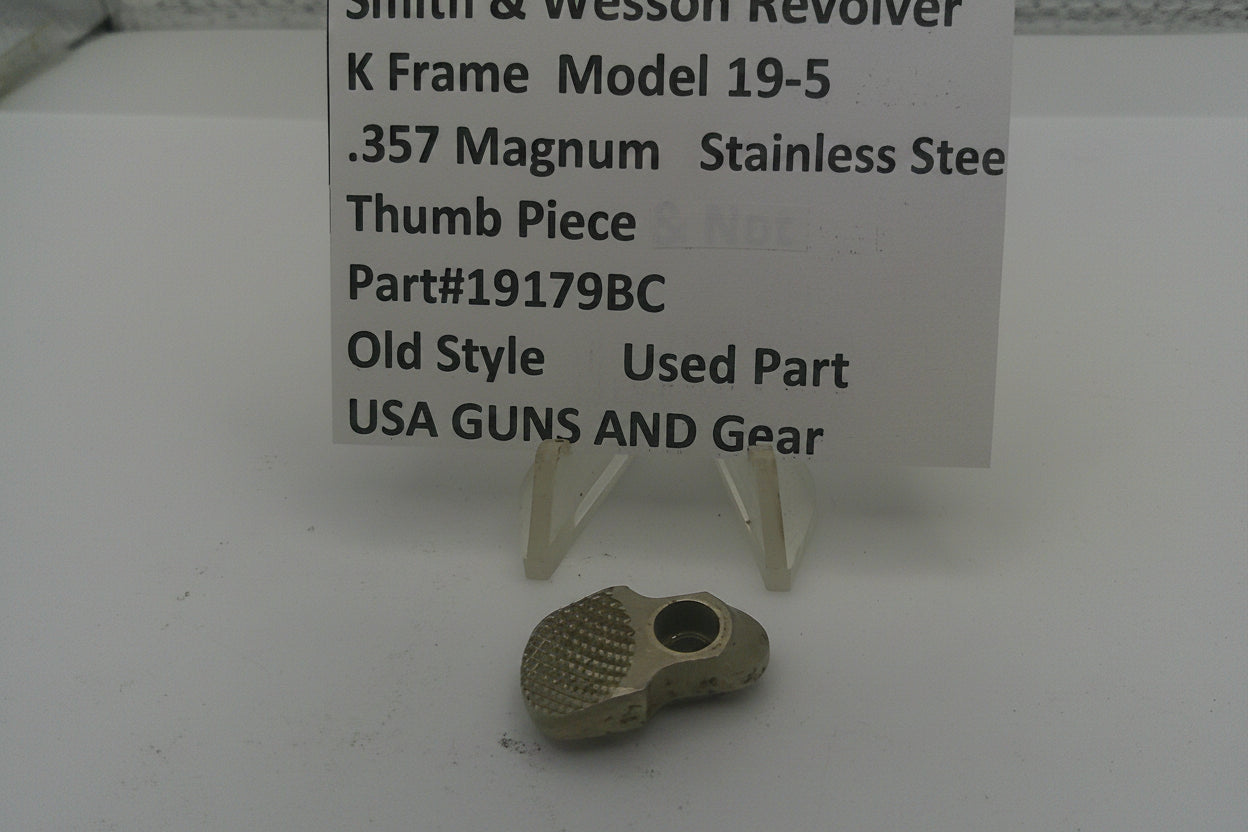Smith & Wesson revolver thumb piece with descriptive sign on a white background