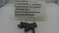 A used black metal Smith & Wesson revolver hammer case part displayed on a small clear stand in front of a white paper label card with product details.