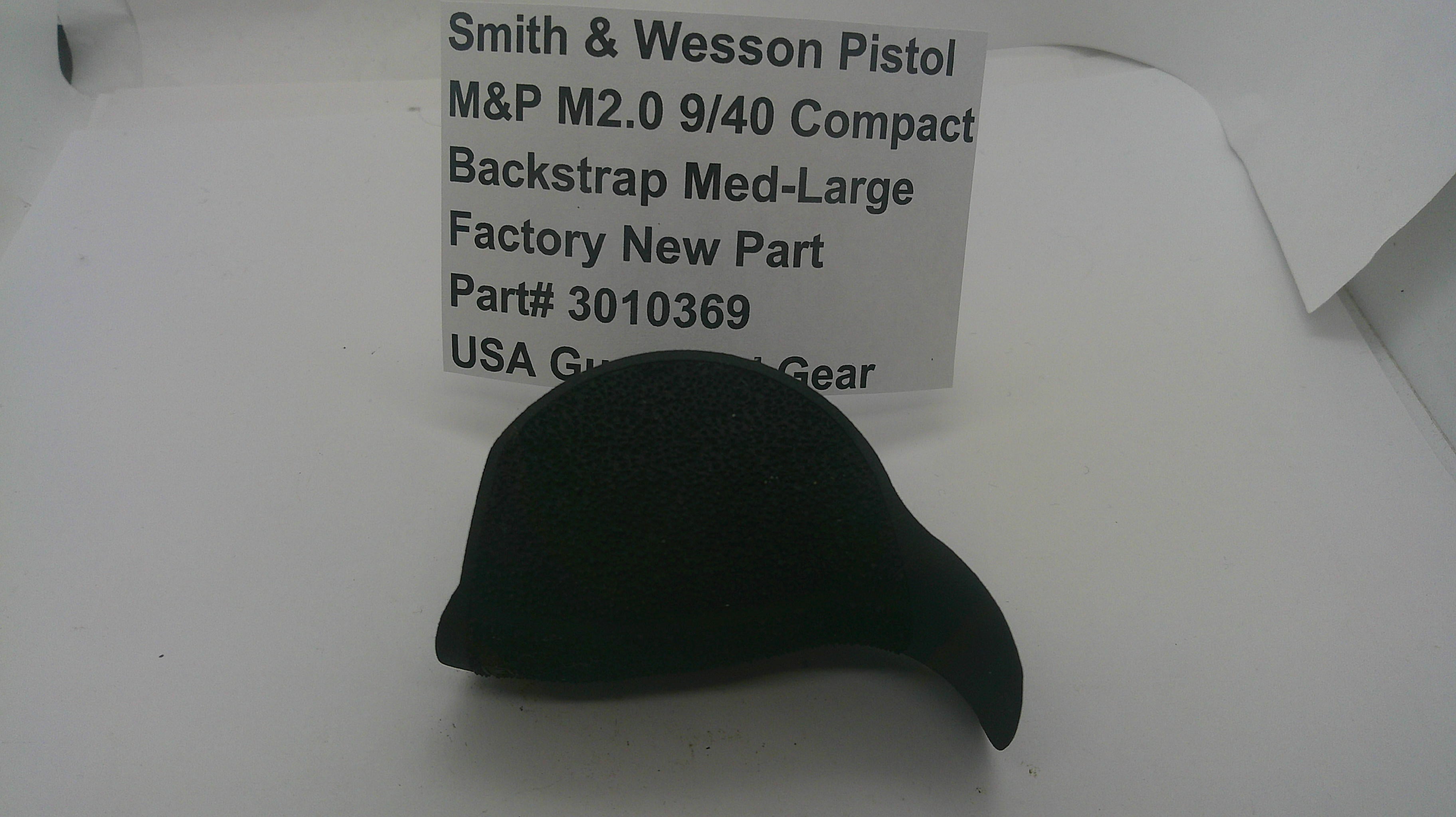 A black fabric backstrap accessory for an M&P 2.0 9/40 Compact pistol, shown on a white surface with a paper label card behind it containing product specifications.