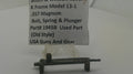 A small used metal part, identified as a bolt, spring, and plunger for a K frame model, displayed on a clear stand with a paper label card. The label reads 'Smith & Wesson Review K Frame Model 13-1 .
