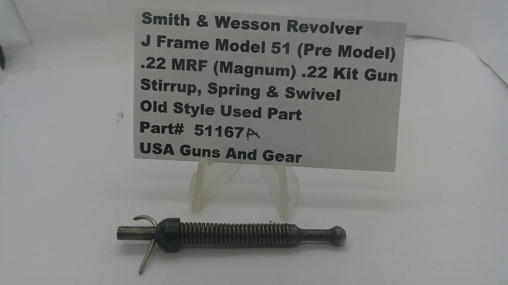 A used metal mechanical part for a Smith & Wesson revolver, displayed on a clear plastic stand with a paper label card. The label details the part number and compatibility.