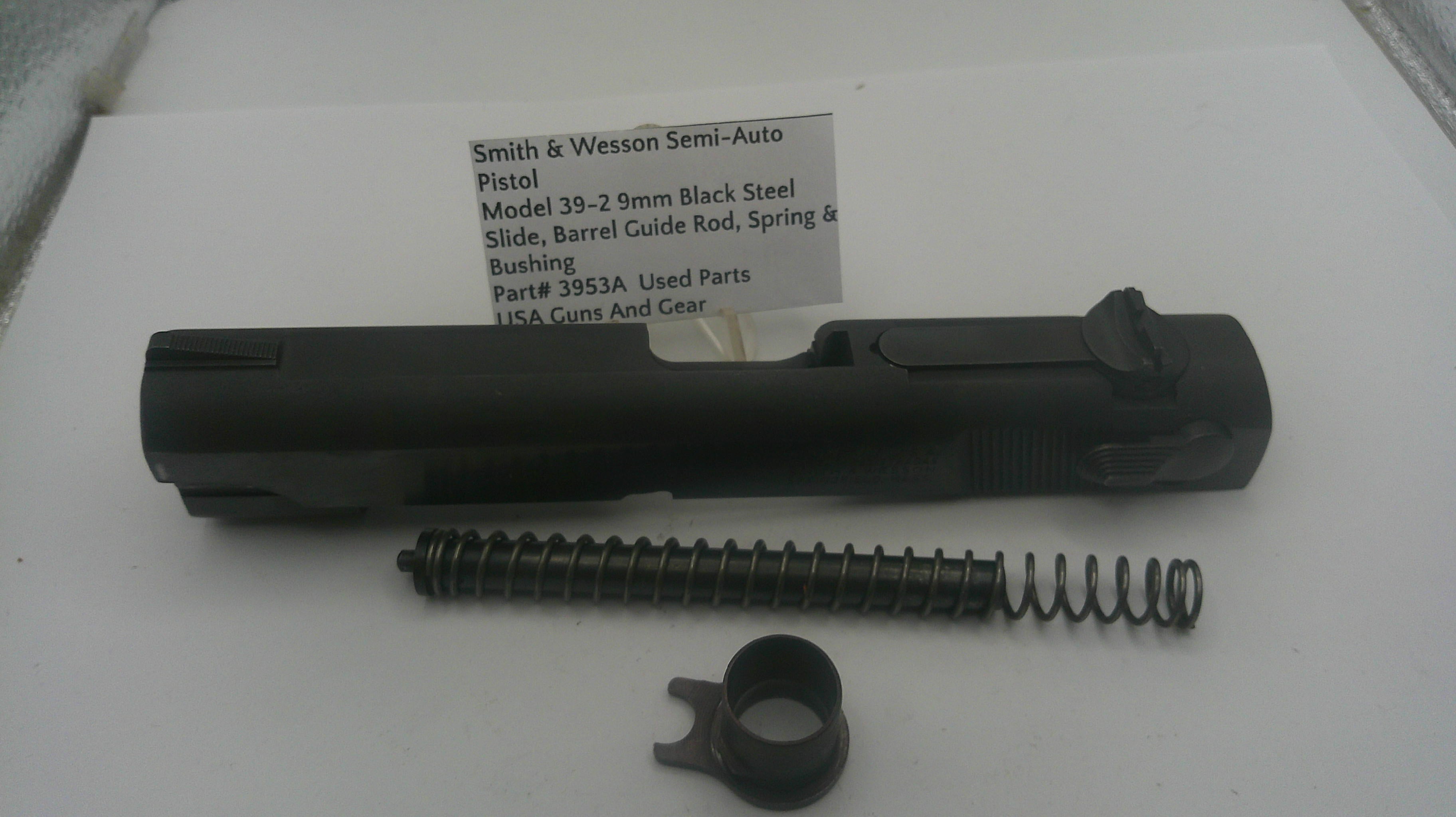 Smith & Wesson semi-auto pistol parts including slide, barrel guide rod, spring, and bushing on a white background.