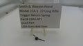 Smith & Wesson pistol trigger return spring with a label on a white background