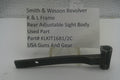 A used black metal sight body part for a Smith & Wesson revolver, displayed on a small stand in front of a white card with product details.