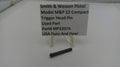 Smith & Wesson pistol trigger head pin with a label on a white background