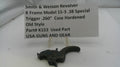 Smith & Wesson revolver trigger with descriptive label on a white background