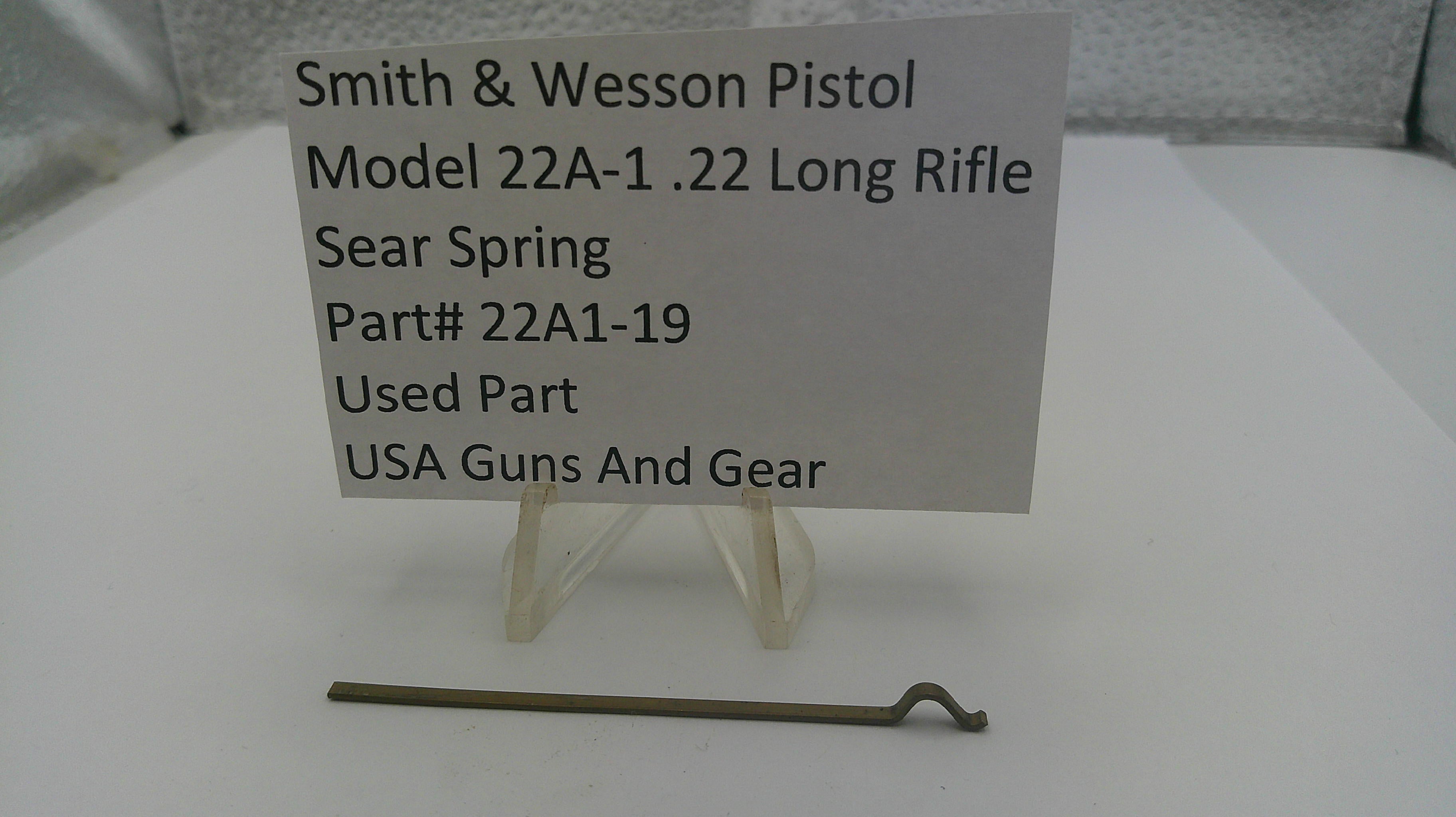 Smith & Wesson pistol sear spring on a stand with a label indicating details.