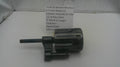 A used black metal Smith & Wesson revolver cylinder assembly and yoke part, shown next to a white paper label with part details, on a white surface.