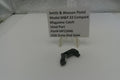 Smith & Wesson pistol magazine catch on a white surface with a label