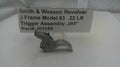 Smith & Wesson Revolver trigger assembly on a white surface with a label