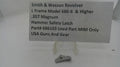 A small metal hammer safety latch part displayed on a clear stand beneath a printed label card that reads 'Smith & Wesson Revolver L Frame Model 686-6 & Higher .357 Magnum Hammer Safety Latch Part# 686103 Used Part MIM Only USA Guns And Gear'.