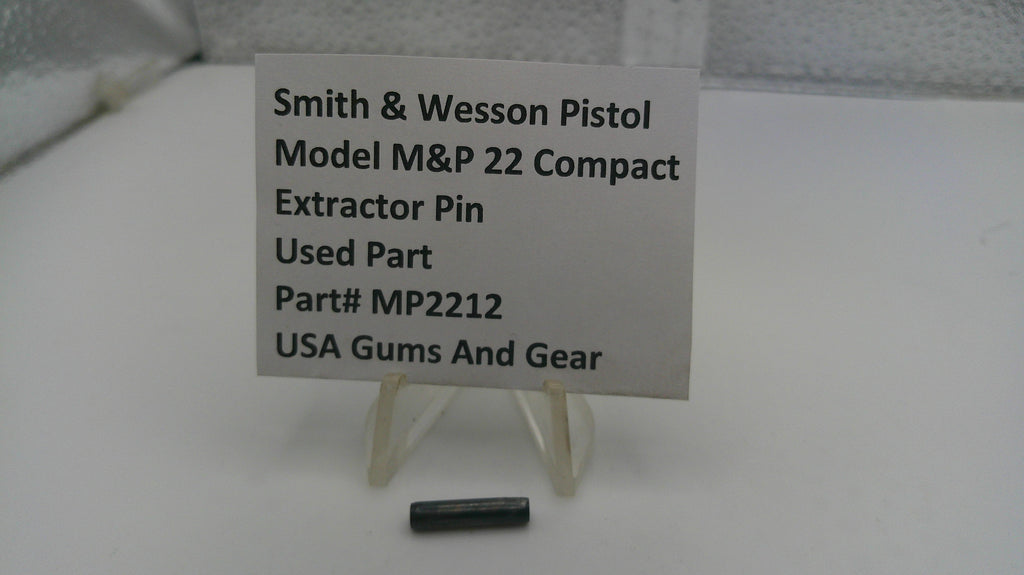 Smith & Wesson pistol part with a label on a white surface