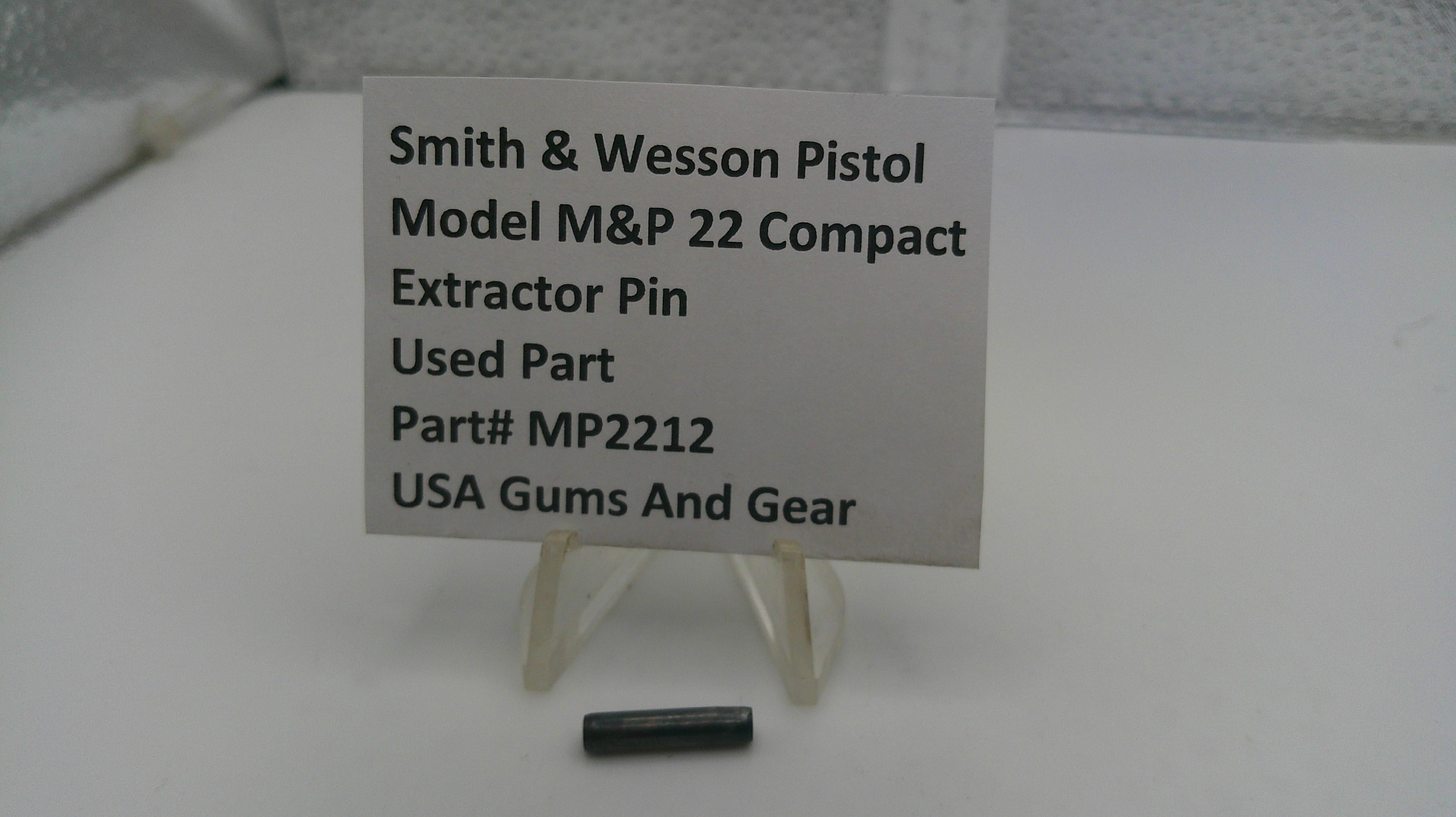 Smith & Wesson pistol part with a label on a white surface