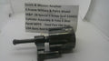 A used metal Smith & Wesson revolver cylinder assembly and yoke 6 shot part, shown with a paper label card in the background on a white surface.
