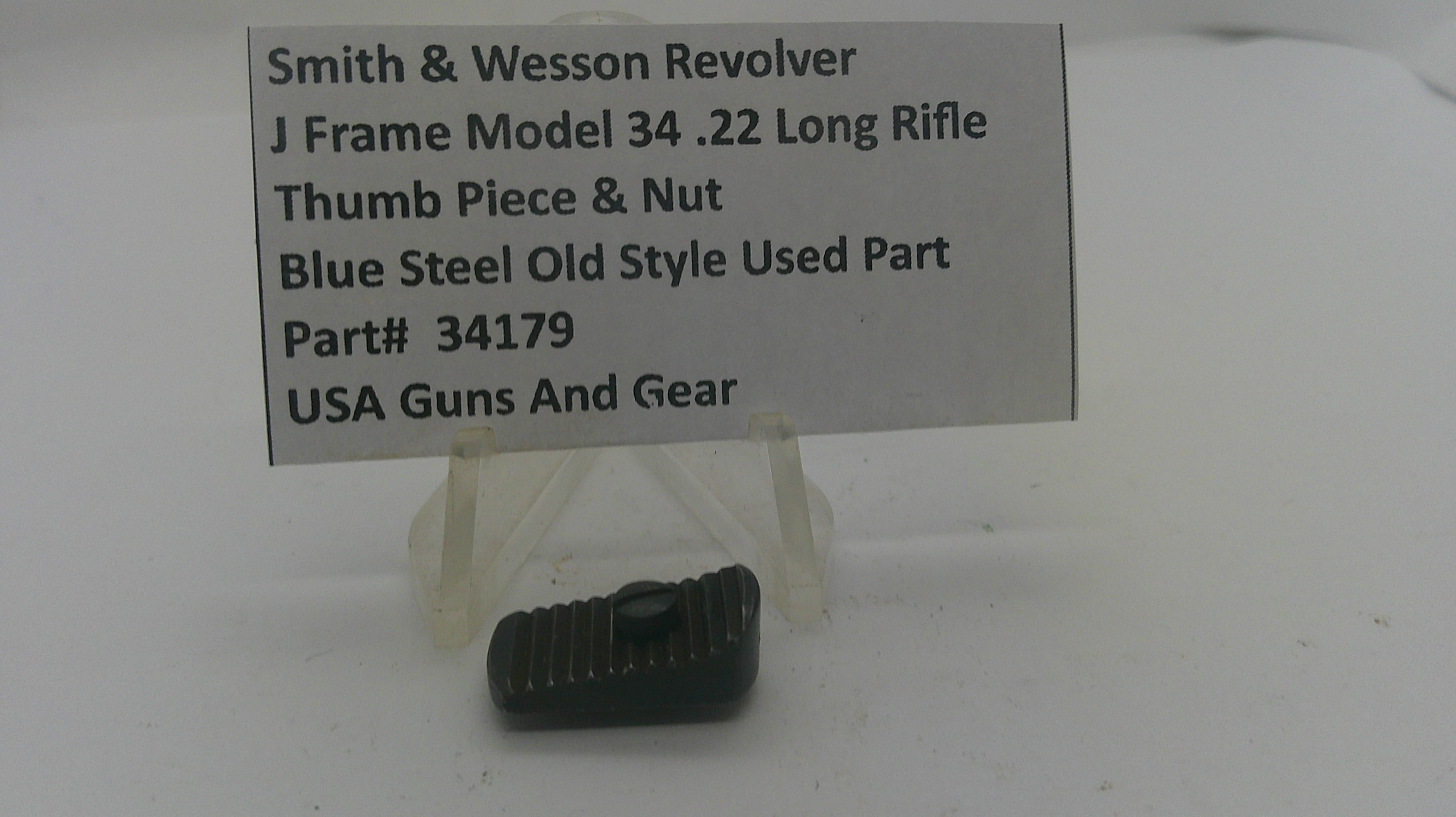 A small dark metal gun part displayed on a clear plastic stand in front of a printed label card. The label reads: Smith & Wesson Revolver, J Frame Model 34 .
