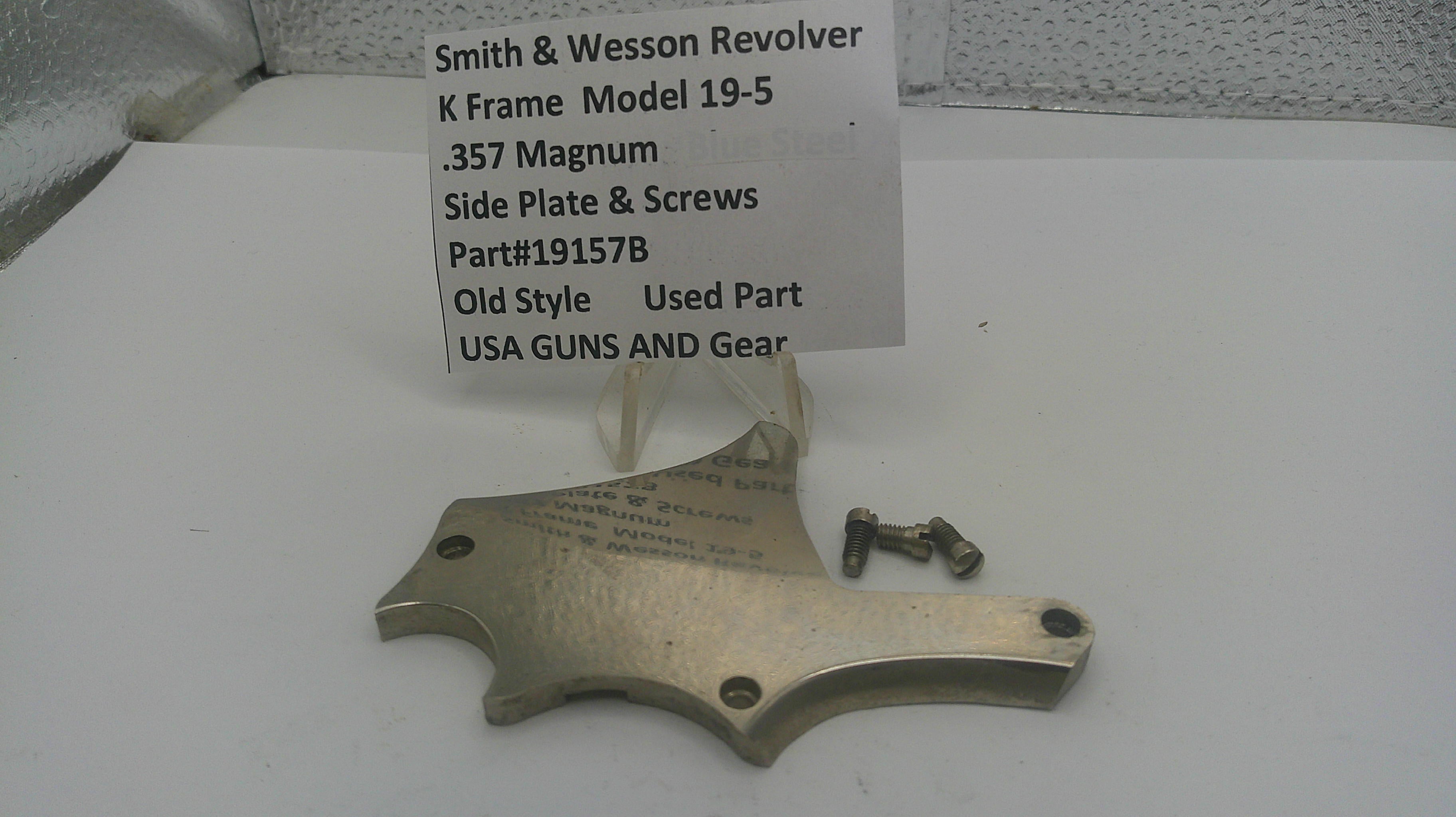 Smith & Wesson revolver side plate and screws on a white surface with a label.
