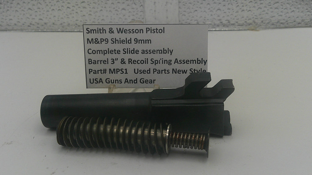 A black metal Smith & Wesson pistol slide assembly with a threaded barrel and recoil spring, displayed on a white surface with a text label in the background.