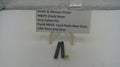 Two small black metal grip safety pins displayed on a clear plastic stand next to a white label card that reads 'Smith & Wesson Pistol M&P9 Shield 9mm Grip Safety Pin Part# MPS5 Used Parts New Style USA Guns And Gear'.