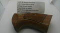 A used wooden revolver grip replacement part, made of brown wood with a textured checkered grip panel and a small brass screw, shown next to a paper label identifying it as a Smith & Wesson revolver part.