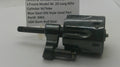 A used black metal revolver cylinder and frame part, photographed on a white surface with a paper label in the background reading Smith & Wesson J Frame Model 34 .22 Long Rifle Cylinder W/Yoke Blue Steel Old Style Used Part Part# 3461 USA Guns And Gear.