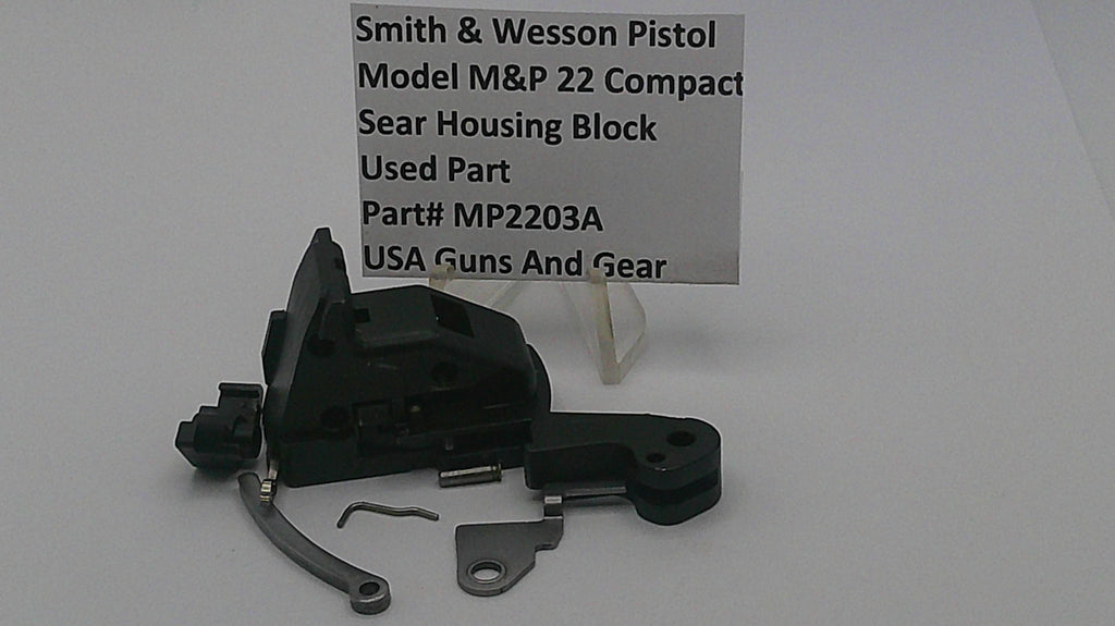 Smith & Wesson pistol part with a label on a white background